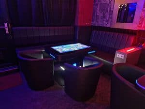 Modernes Touch-Interface im Lounge-Bereich, LED-beleuchteter Tisch in einer stilvollen Bar-Umgebung, entspanntes Ambiente.