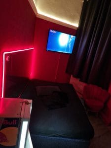 Modernes Hotelzimmer mit rotem Akzent, Flachbildfernseher und stilvollem Ambiente im Noble Atlas.