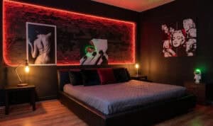 Moderne Schlafzimmergestaltung mit stilvoller Beleuchtung und Kunstwerken an der Wand.