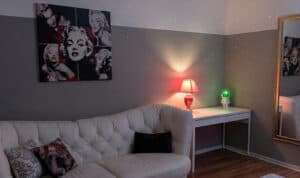 Pop-Art Wandbilder im Wohnzimmer mit Sofa, Lampe und Spiegel.